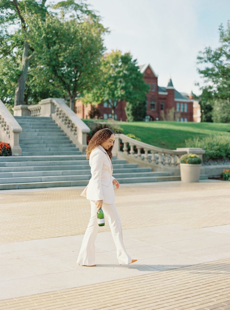 girl walks around with a bottle of champagne around syracuse, NY
