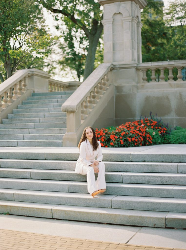 Girl sitting on stairs at syracuse university campus during graduation photo session